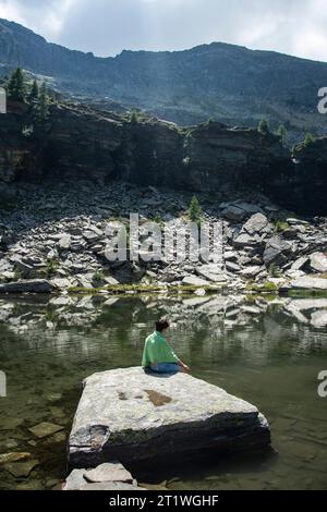 Wanderer an idyllischem Bergsee im wilden und abgelegenen Val Marcri im Tessin Stockfoto