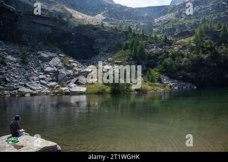 Wanderer an idyllischem Bergsee im wilden und abgelegenen Val Marcri im Tessin Stockfoto