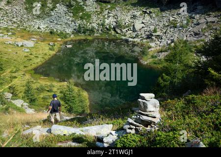 Wanderer an idyllischem Bergsee im wilden und abgelegenen Val Marcri im Tessin Stockfoto