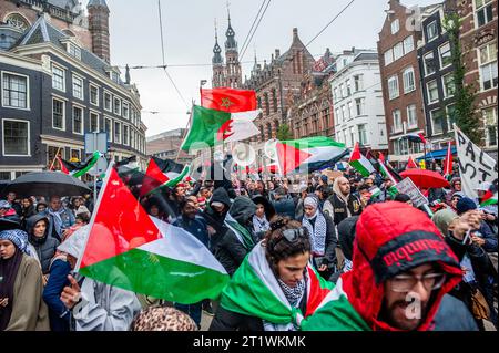 Amsterdam, Niederlande. Oktober 2023. Demonstranten marschieren mit palästinensischen Flaggen während einer Demonstration in Solidarität mit Palästina. Die palästinensische Gemeinschaft in den Niederlanden organisierte einen marsch im Zentrum der Stadt, um die Regierung Israels zu verurteilen und Solidarität mit dem palästinensischen Volk zu bekunden. Quelle: SOPA Images Limited/Alamy Live News Stockfoto