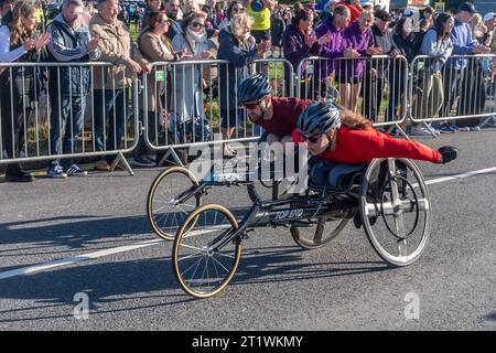 Great South Run, 15. Oktober 2023, Portsmouth, Hampshire, England, UK. Tausende von Teilnehmern nahmen am 10 Mile Great South Run Teil, der in Southsea, Portsmouth, begann und endete. Neben den Elite-Läufern nahmen auch viele andere Teilnehmer Teil, die für Wohltätigkeitsorganisationen oder ihre Vereine gelaufen waren. Zwei Rollstuhlfahrer kurz nach dem Start des Rennens. Stockfoto