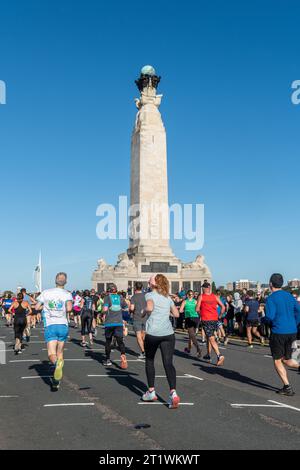 Great South Run, 15. Oktober 2023, Portsmouth, Hampshire, England, UK. Tausende von Teilnehmern liefen im 16-Mile-Great South Run in Southsea, Portsmouth. Neben den Elite-Läufern nahmen auch viele andere Teilnehmer Teil, die für Wohltätigkeitsorganisationen oder ihre Vereine gelaufen waren. Im Bild: Viele Läufer passieren das Portsmouth Naval Memorial Stockfoto