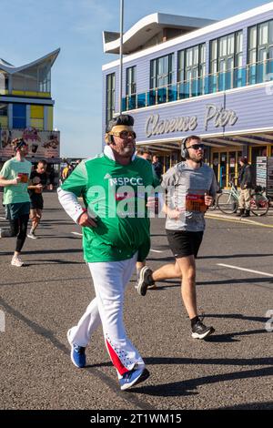 Great South Run, 15. Oktober 2023, Portsmouth, Hampshire, England, UK. Tausende von Teilnehmern liefen im 16-Mile-Great South Run in Southsea, Portsmouth. Neben den Elite-Läufern nahmen auch viele andere Teilnehmer Teil, die für Wohltätigkeitsorganisationen oder ihre Vereine gelaufen waren. Im Bild: Ein Mann, der als Elvis verkleidet ist, am Clarence Pier vorbeifährt Stockfoto