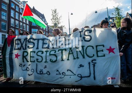 Amsterdam, Niederlande. Oktober 2023. Die Demonstranten halten während einer Demonstration in Solidarität mit Palästina ein Banner. Die palästinensische Gemeinschaft in den Niederlanden organisierte einen marsch im Zentrum der Stadt, um die Regierung Israels zu verurteilen und Solidarität mit dem palästinensischen Volk zu bekunden. (Foto: Ana Fernandez/SOPA Images/SIPA USA) Credit: SIPA USA/Alamy Live News Stockfoto