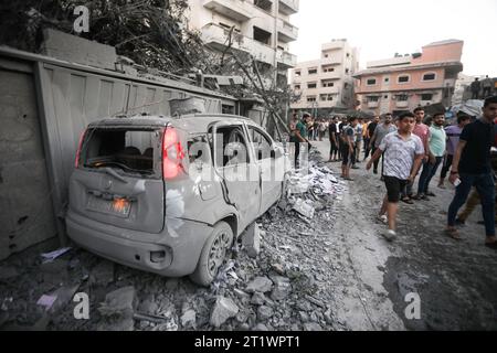 Rafah, Gaza. Oktober 2023. Nach einem israelischen Streik in Rafah im südlichen Gazastreifen am Sonntag, den 15. Oktober 2023, stehen Menschen in der Nähe eines verbrannten Autos. Die Vereinten Nationen berichteten, dass bereits mehr als 400.000 Palästinenser aus dem Norden des Gazastreifens geflohen sind, nachdem ein massiver israelischer Luftangriff mehr als 2000 Palästinenser getötet hat, die Hälfte davon Kinder und Frauen. Foto: Ismael Mohamad/UPI Credit: UPI/Alamy Live News Stockfoto