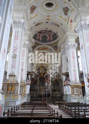 Blick auf den Chor mit rotem Teppich und Hochaltar mit großem Bild in der barocken Klosterkirche Schöntal Stockfoto