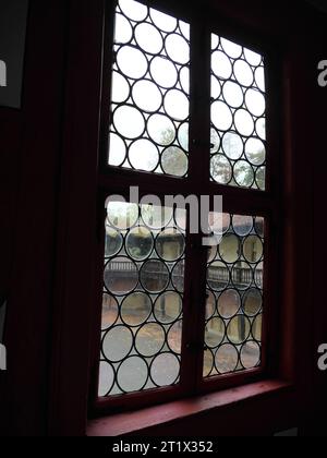 Blick durch bleiverglaste Fenster auf den Innenhof des Schlosses Götzenburg in Jagsthausen Stockfoto