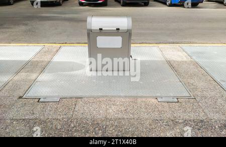 Unterirdischer Stahlkipper seitlich. Autos parken schräg vorn seitlich Stockfoto