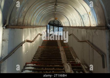 Treppen in der Stadt. Tunnel nach oben. Stufen im Schnee. Fußgängerüberquerung über die Autobahn. Stockfoto