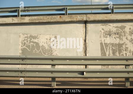Anschlagpunkt in der Nähe der Autobahn. Mauer auf der Autobahn. Ausfahrt Strassa. Verkehrsarchitektur. Stockfoto