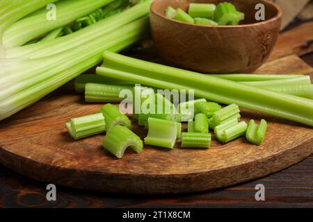 Brett mit frisch geschnittenen Selleriestangen auf Holztisch, Großaufnahme Stockfoto