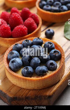 Tartlet mit frischen Heidelbeeren auf Holzbrett. Köstliches Dessert Stockfoto