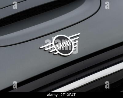 Minigartenlogo des britischen Autoherstellers. Emblem auf einer grauen Kapuze des Mini Cooper S. das Symbol außen in Nahaufnahme. Stockfoto