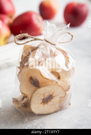 Bio getrocknete Apfelringe in klarer Verpackung und rote reife Äpfel in Box.AI Generative Stockfoto