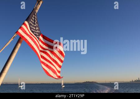 Die amerikanische Flagge fliegt gegen den Himmel. Aufgenommen auf der Rückseite einer Fähre. Stockfoto