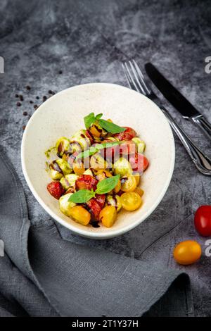 Salat aus gelben und roten Kirschtomaten verschiedener Sorten mit Kräutern von oben Stockfoto