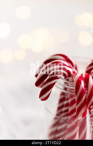 Vertikales Bild des Glases mit weihnachtlichen Bonbons mit Kopierraum auf weißem Hintergrund Stockfoto