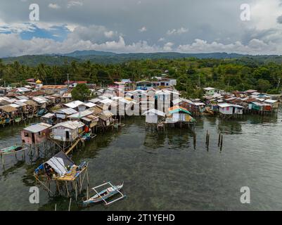 Boote aus der Vogelperspektive neben Häusern am Wasser in Zamboanga auf Stelzen. Mindanao, Philippinen. Stockfoto