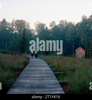 Zwei Frauen laufen auf einer gewundenen Promenade in einer kleinen Gemeinde. Stockfoto