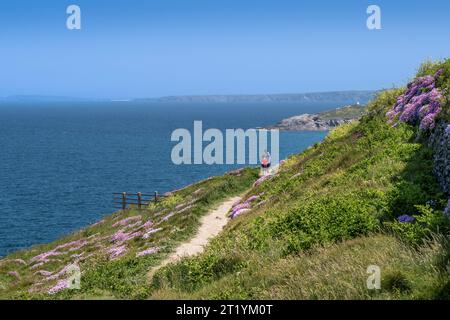 Zwei Personen stehen auf dem Küstenweg, der nach Fistral in Newquay in Cornwall in Großbritannien führt Stockfoto