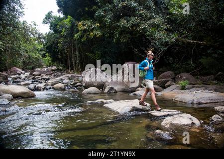 Eine junge Frau wandert durch den Dschungel von Puerto Rico auf einem Abenteuer an einem sonnigen Tag. Stockfoto