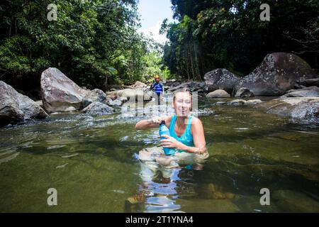 Eine junge Frau wandert durch den Dschungel von Puerto Rico auf einem Abenteuer an einem sonnigen Tag. Stockfoto