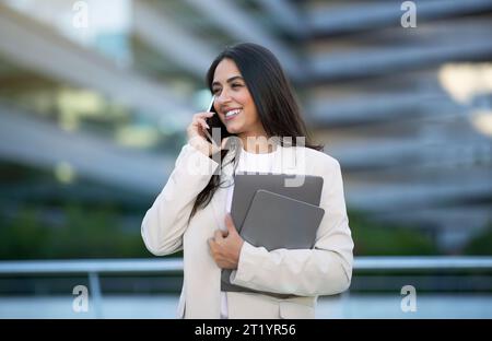 Glückliche Junge Geschäftsfrau, Die Draußen Auf Dem Handy Spricht Stockfoto