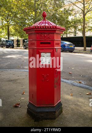 Ein sechseckiger roter Briefkasten aus viktorianischer Zeit, bekannt als „Penfold“, der erstmals 1866 eingeführt wurde und noch heute in den Kensington Palace Gardens in London, Großbritannien, verwendet wird. Das war es Stockfoto