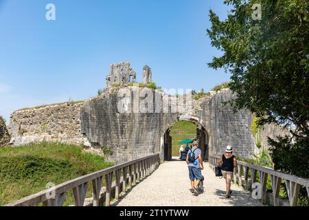 Corfe Castle in Devon England, Besucher des Schlosses begeben sich an einem sonnigen Herbsttag 2023 in Richtung Eingangsbogen, historische Burgruinen, England, Großbritannien Stockfoto