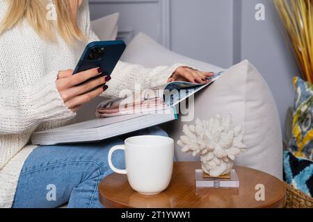 Weibliche Hand hält Kaffeetasse Lesebuch Stockfoto