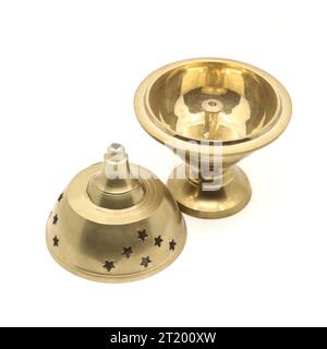 Eine göttliche Räucherstäbchen-Diya-Lampe mit einzigartiger Form aus goldenem Messingmetall, die für religiöse Feiern in einem weißen Hintergrund verwendet wird Stockfoto
