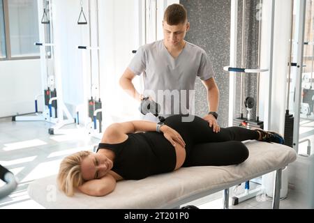 Spezialist in einem Wellnesscenter verwendet ein spezielles physiotherapeutisches Gerät Stockfoto