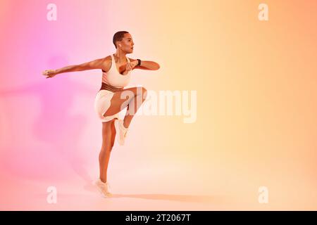 Eine junge, zielgerichtete lateinfrau in Sportbekleidung und Kopfhörern läuft, springt, macht aktives Workout Stockfoto
