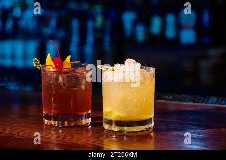 Tropische negroni und Caipirinha mit Eis- und Kirschdekoration mit Barhintergrund, Konzept Stockfoto