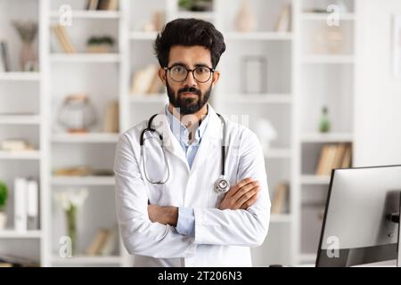 Professioneller Mann im weißen Mantel in der Nähe des Kliniktisches Stockfoto