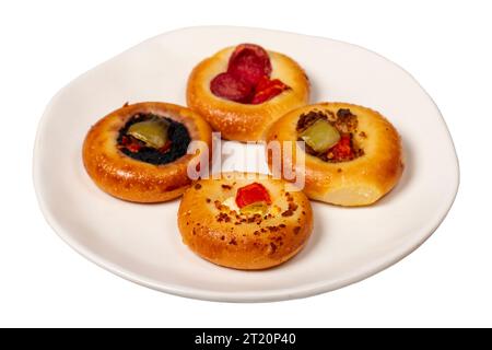 Kleine Pizzasorten. Mini-Pizzen mit Wurst, Gurken, Tomaten, Mozzarella, Petersilie, grün isoliert auf weißem Hintergrund. Stockfoto