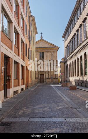 Eine Straße in Parma und im Hintergrund die entgliederte Renaissancekirche San Marcellino, Italien. Stockfoto