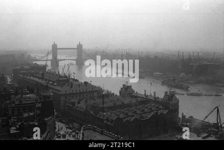 1950er Jahre, historischer, aus der Vogelperspektive über die Themse, mit Blick auf die Tower Bridge, die Werften am Fluss und die Skyline von London aus der Lower Thames Street, Billingsgate, London, England, Großbritannien. Stockfoto