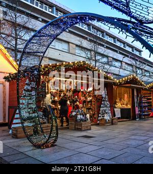 Weihnachtslichter verleihen den kleinen Holzständen auf Plymouth’s Christmas Market im Jahr 2021 Wärme, Masken zeigen COVID Is about. Stockfoto
