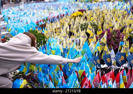 Kiew, Ukraine. Oktober 2023. Eine Frau setzt eine ukrainische Flagge an die gefallenen Soldaten an der provisorischen Gedenkstätte auf dem Independent Square. Tausende von Flaggen wurden an der provisorischen Gedenkstätte für die gefallenen Soldaten auf dem Unabhängigkeitsplatz in Kiew gepflanzt. Jede Flagge ist eine Hommage an gefallene Soldaten, die seit Februar 2022 im Russisch-Ukrainischen Krieg für die Ukraine kämpfen. Quelle: SOPA Images Limited/Alamy Live News Stockfoto