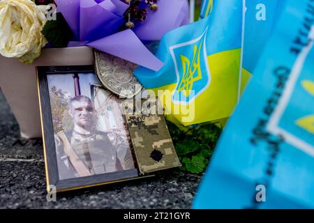 Kiew, Ukraine. Oktober 2023. Ein Porträt eines gefallenen Soldaten ist mit einer Blumenkredite an der provisorischen Gedenkstätte auf dem Independent Square in Kiew, Ukraine, zu sehen. Tausende von Flaggen wurden an der provisorischen Gedenkstätte für die gefallenen Soldaten auf dem Unabhängigkeitsplatz in Kiew gepflanzt. Jede Flagge ist eine Hommage an gefallene Soldaten, die seit Februar 2022 im Russisch-Ukrainischen Krieg für die Ukraine kämpfen. Quelle: SOPA Images Limited/Alamy Live News Stockfoto