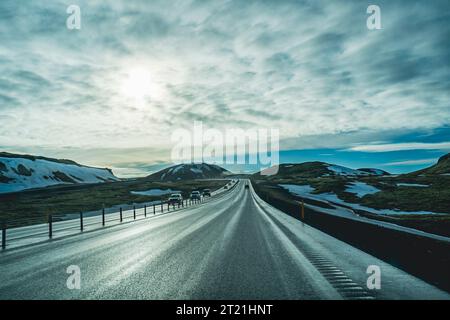 Ein malerischer Blick auf einen langen Abschnitt der Autobahn, der sich durch eine ländliche Landschaft schlängelt, mit zahlreichen Autos, die entlang der Straße fahren Stockfoto