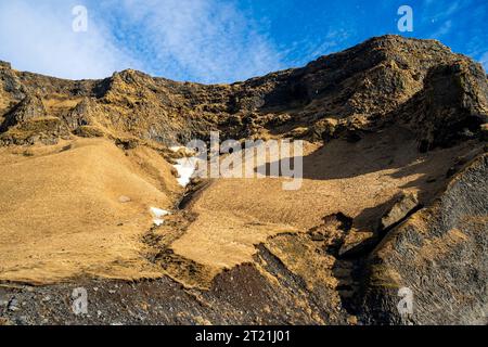 Die felsigen und trockenen Berge Islands, die teilweise von einer Schneedecke bedeckt sind Stockfoto