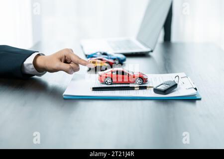 Geschäftskonzept, Kfz-Versicherung, Auto verkaufen und kaufen, Kfz-Finanzierung, Kfz-Schlüssel für Kfz-Kaufvertrag. Ein Autohändler erklärt den Kunden über l Stockfoto