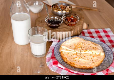 Süße runde Pfannkuchen, die auf einem runden Teller neben Marmelade liegen Stockfoto