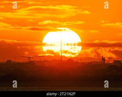 Der Sonnenuntergang wurde von Sutton Strand aus mit dem Spire in Dublin City ausgerichtet Stockfoto