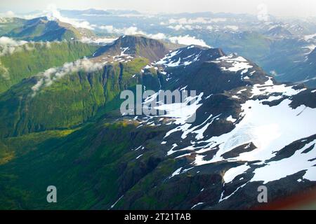 Blick aus der Vogelperspektive auf zerklüftete Berggipfel im Kodiak National Wildlife Refuge, Alaska. Das Bild zeigt das weite, ungezähmte Gelände, das für diese Region typisch ist. Die bergige Landschaft ist im Winter oft mit Schnee bedeckt und bietet Lebensraum für verschiedene Tierarten. Stockfoto
