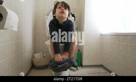 Kindertopf-Trainingskonzept, kleiner Junge auf Toilette sitzend Hygiene und Unabhängigkeit im Bad Stockfoto