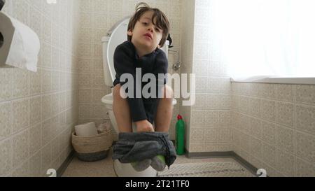 Kindertopf-Trainingskonzept, kleiner Junge auf Toilette sitzend Hygiene und Unabhängigkeit im Bad Stockfoto