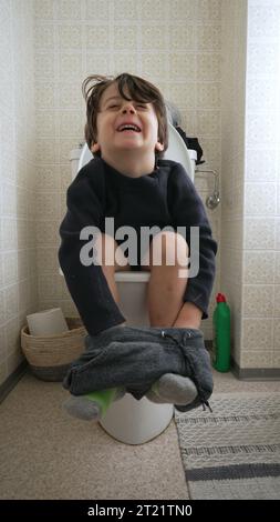 Ein kleiner Junge sitzt auf Toilette im Badezimmer, Kindertopf-Training-Konzept im vertikalen Video Stockfoto